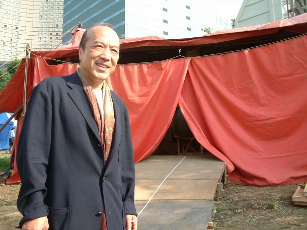写真・図版 : 紅テントの前に立つ唐十郎＝2002年、東京・新宿