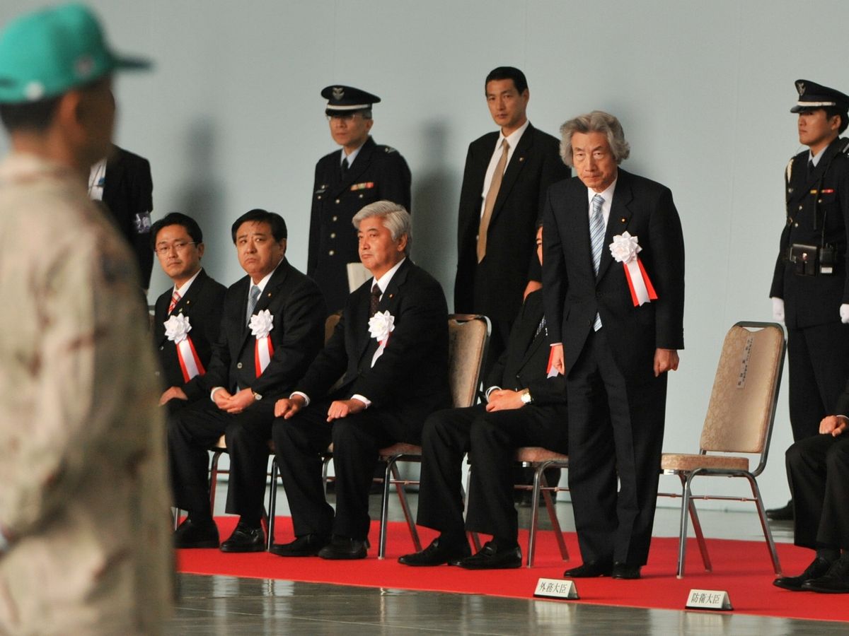 写真・図版 : 2008年、イラク復興支援派遣輸送航空隊の帰国行事で紹介されて立つ小泉元首相＝愛知県小牧市の航空自衛隊小牧基地。朝日新聞社