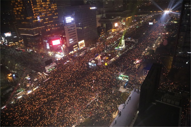 写真・図版 : 朴槿恵大統領（当時）の辞任を求める集会は、参加者のろうそくで埋め尽くされた＝2016年11月、ソウル