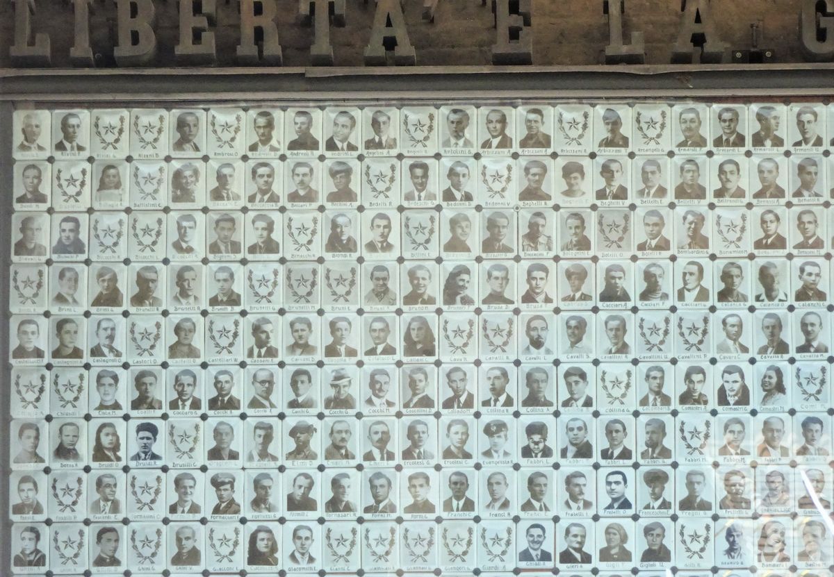 写真・図版 : 市庁舎の壁に掲げられた、亡くなったパルチザンの人々の写真＝2019年、筆者撮影