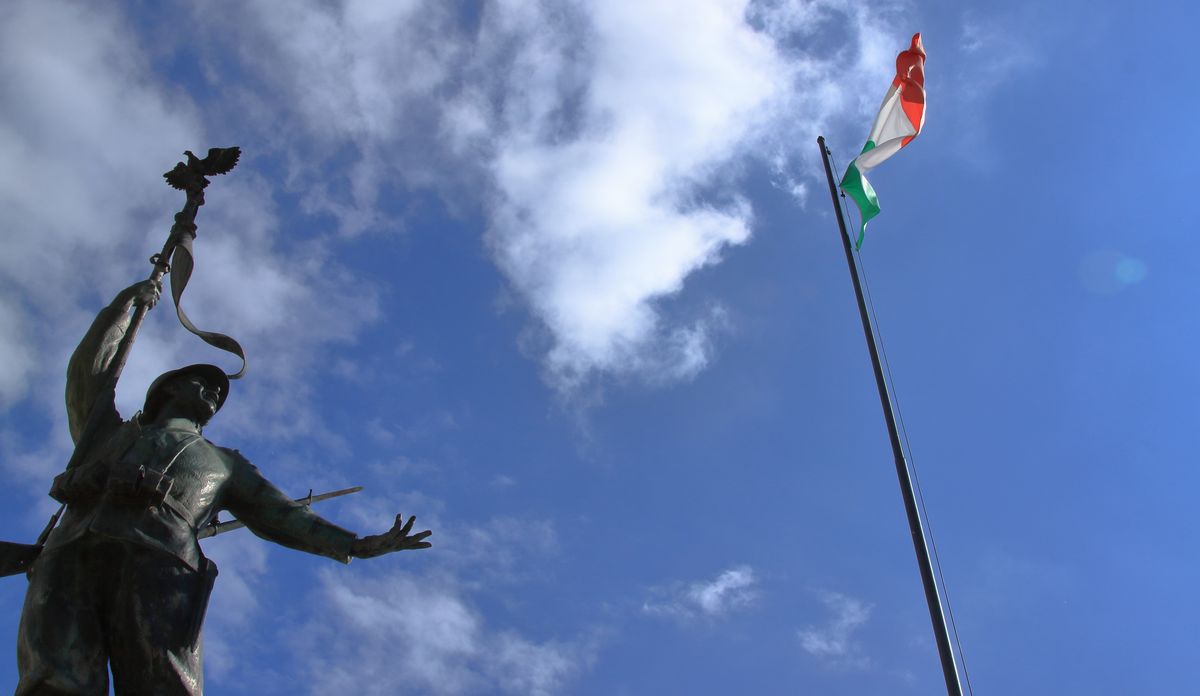 写真・図版 : イタリアの三色旗とパルチザンの銅像（savo1974 / shutterstock.com）