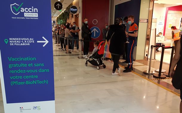 写真・図版 : マクロン大統領の演説の翌日、パリ郊外のショッピングモール内の予約不要のワクチン接種会場の前にできた行列＝2021年7月13日
