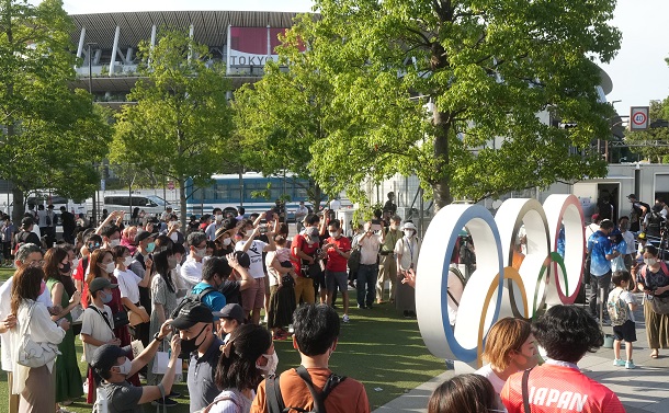 写真・図版 : 国立競技場の近くにある五輪モニュメント前で記念写真を撮る人たち。五輪のためにあちこちで人は集まった＝2021年7月23日、東京都新宿区