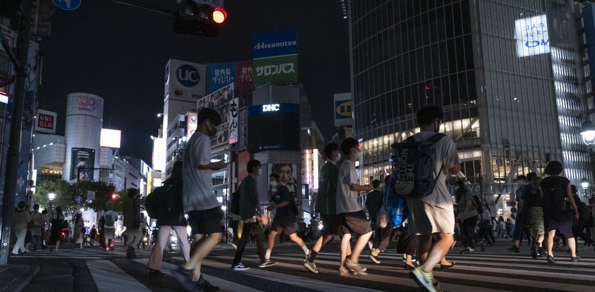 写真・図版 : 緊急事態宣言中の東京・渋谷のスクランブル交差点。午後8時をすぎて広告の明かりが消えても人波が続いた＝2021年7月28日