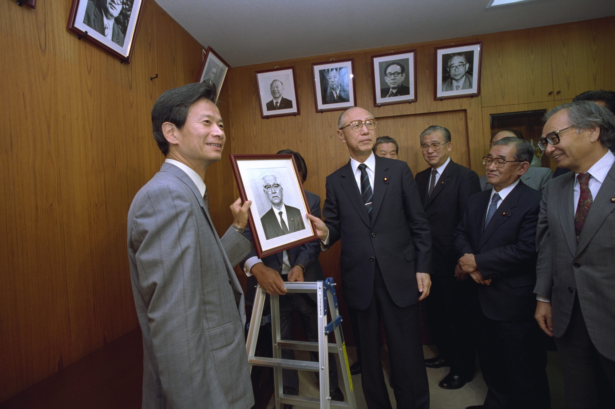写真・図版 : 父・江田三郎氏の写真が、旧社会党委員長室に掲げられた際の江田五月氏（左端）＝1992年撮影