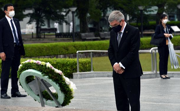 写真・図版 : IOC President Thomas Bach offers flowers and a moment of silence at the Cenotaph for the A-bomb Victims, Hiroshima, July 16, 2021.