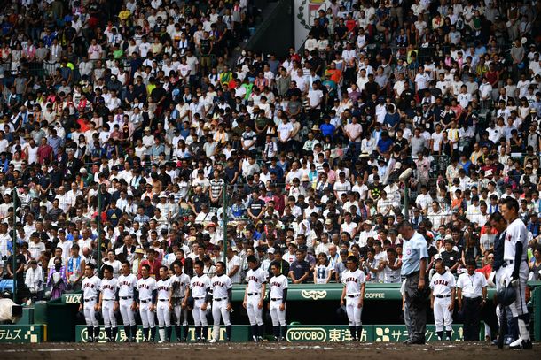 写真・図版 : As sirens interrupt the game, baseball players of Konan High School, from Okinawa, take a moment of silence at Hanshin Koshien Stadium, at noon on August 15, 2018.