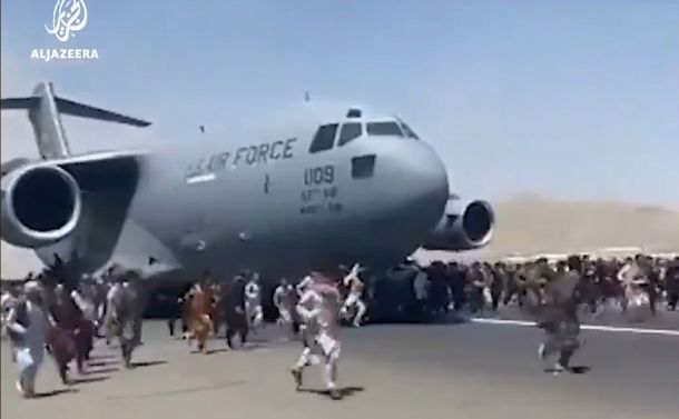 写真・図版 : カブールの国際空港で、米軍機に群がる人々。機体にしがみつく人も多く見られた＝衛星放送局アルジャジーラがツイッターに投稿した動画から 
