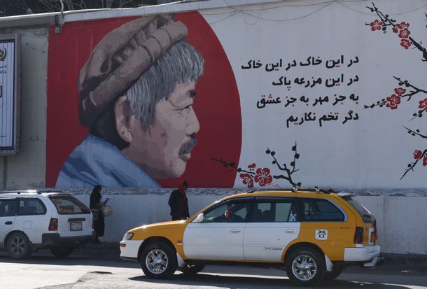 写真・図版 : 中村哲さんの殺害事件の後、アフガニスタンの首都カブールに立つ壁に描かれた中村さんの肖像画。「大地に優しさや愛の種をまくのはいいが、問題の種をまいてはいけない」という趣旨のメッセージが添えられている＝2020年1月25日