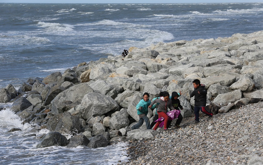 写真・図版 : 海岸で遊ぶ子供たち。後方は岩の防波堤＝2017年6月、米アラスカ州シシュマレフ、葛谷晋吾撮影