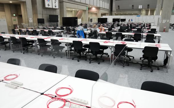 写真・図版 : 東京五輪・パラリンピックのメインプレスセンター。報道陣の作業スペースには、透明なついたてが設置されていた＝2021年7月1日、東京都江東区