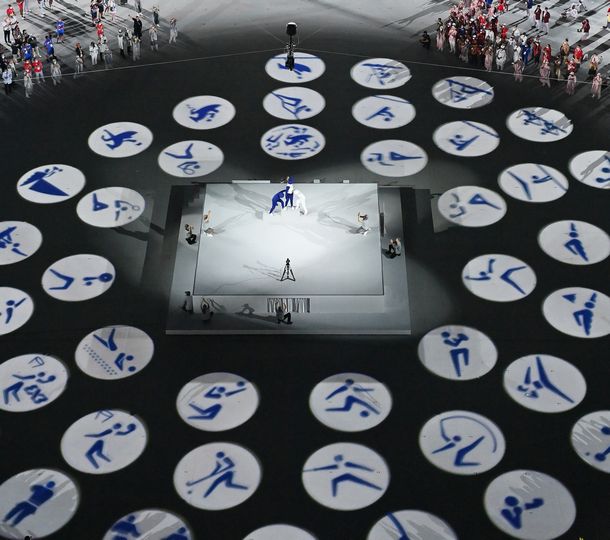 写真・図版 : 五輪開会式でフィールドに映し出された各競技のピクトグラム＝2021年7月23日、国立競技場