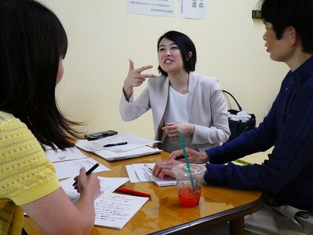 写真・図版 : 聴覚障害がある人たちが開く勉強会に向けて手話で打ち合わせをする筆者（中央）＝2018年6月30日、東京都内