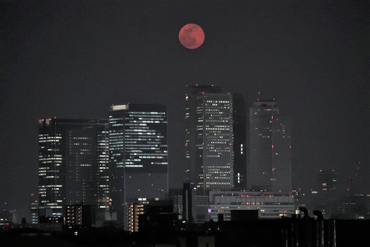 写真・図版 : 名古屋駅前の高層ビル群の上に浮かんだスーパームーン＝2020年4月8日