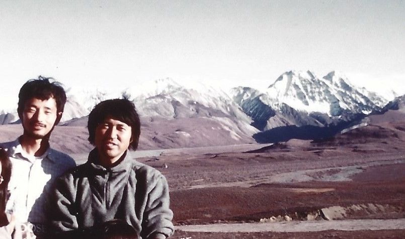写真・図版 : 1988年9月18日、留学生ら日本人3人を連れてデナリ国立公園に行った時、ばったり出会った星野さんと撮った写真。バックは北米最高峰のデナリ（旧マッキンリー）。