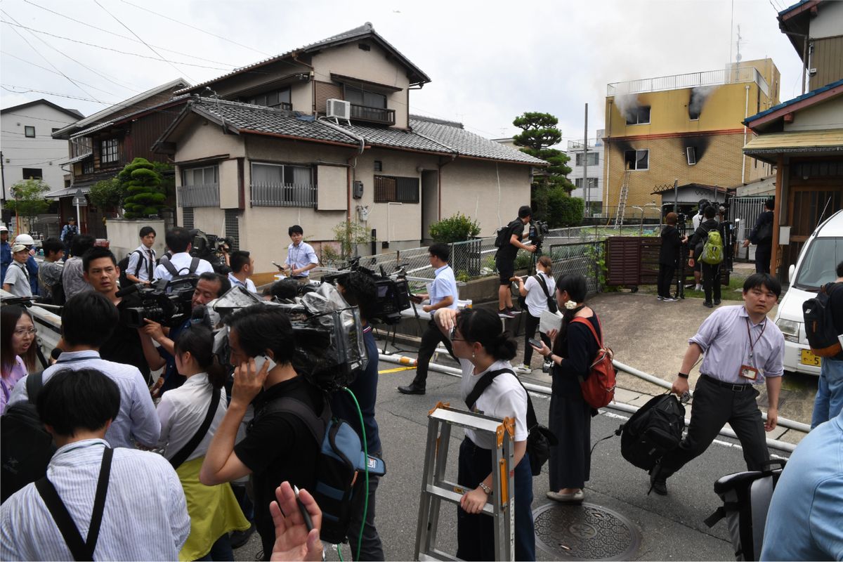 写真・図版 : 2019年7月に起きた京都アニメーション放火殺人事件では、犠牲者全員の実名が公表されたのは発生から40日後のこと。遺族に対するメディアスクラム（集団的過熱取材）などを考慮しての措置だった。写真は火災現場近くで取材する報道各社＝2019年7月18日、京都市伏見区