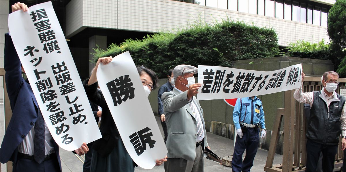 写真・図版 : 判決後、「勝訴」などと書かれた紙を掲げる原告側弁護士ら＝2021年9月27日、東京・霞が関の東京地裁前