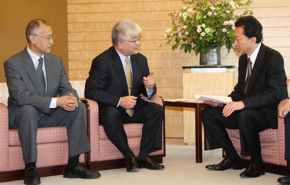 写真・図版 : 2010年、当時の鳩山由紀夫首相と会談する金澤一郎氏（中央）
