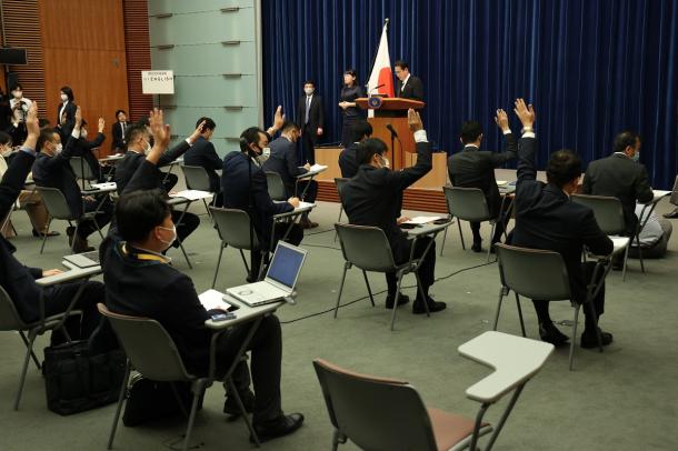 写真・図版 : 岸田文雄首相の会見で質問のため挙手する記者たち＝2021年10月4日、首相官邸