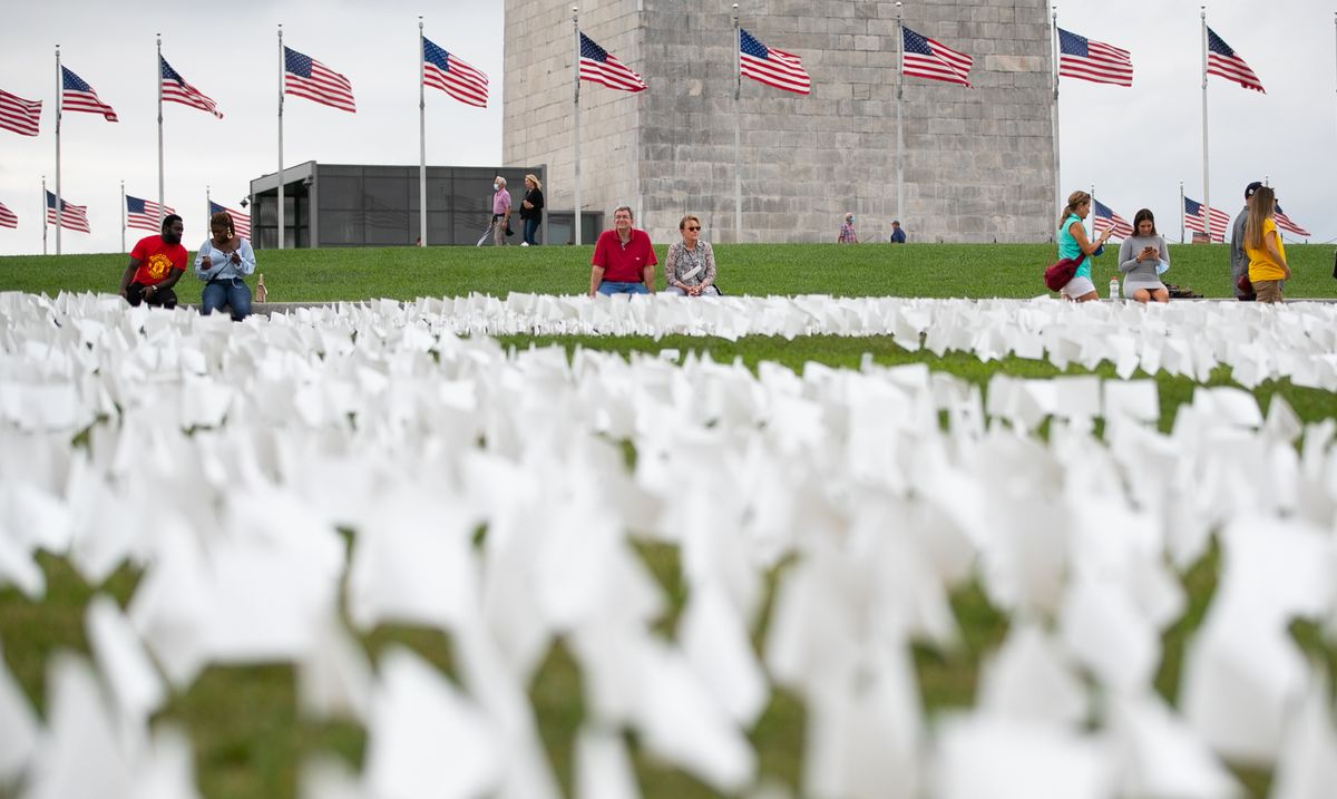写真・図版 : ワシントンのナショナルモールに、米国で新型コロナウイルスによって亡くなった人を悼む約67万本の白い旗が立てられた。遺族らがメッセージを書き込んでいた＝2021年9月17日