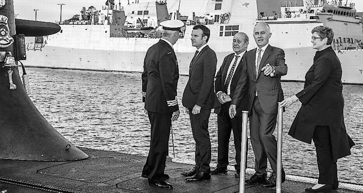 写真・図版 : シドニーで豪海軍の潜水艦の上に乗るマクロン仏大統領（左から2番目）とターンブル豪首相（当時、右から2番目）＝2018年5月