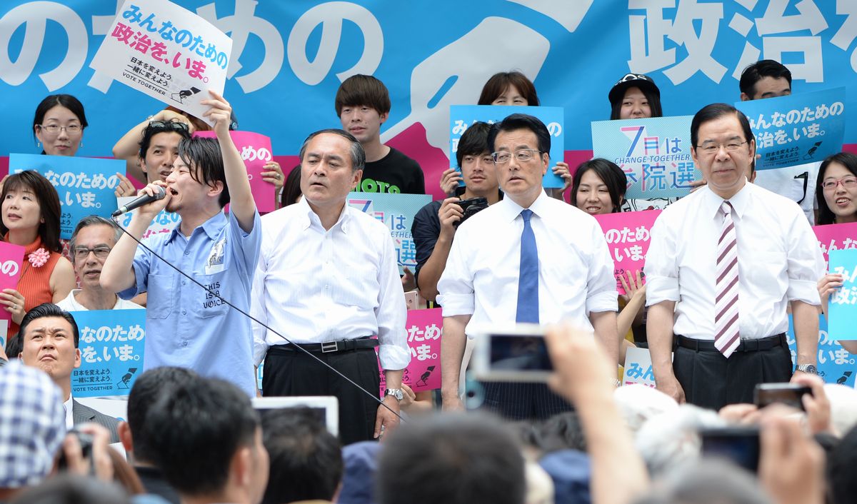 写真・図版 : 市民連合と野党の合同集会でマイクを握るSEALDsの奥田愛基さん（壇上左端）と共産党の志位和夫委員長（同右端）、民進党の岡田克也代表（同右から2人目）ら＝2016年6月19日、東京・有楽町