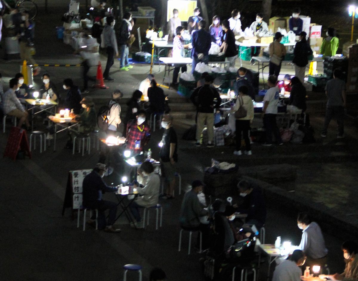 写真・図版 : NPO法人「TENOHASI」が実施した弁当配布と生活相談。日没後も相談が続いた＝2021年9月25日、東京都豊島区の東池袋中央公園