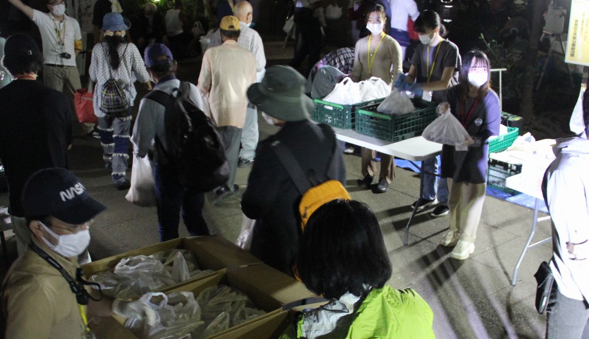 写真・図版 : 生活困窮者の支援団体「TENOHASI」が実施した炊き出しと生活相談。並んだ人たちは次々と弁当を受け取った＝2021年9月、東京都豊島区の東池袋中央公園