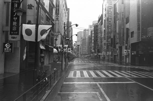 写真・図版 : 昭和天皇の「大喪の礼」が行われた1989年2月24日。東京・新宿の繁華街はガランとし、弔旗だけが目についた