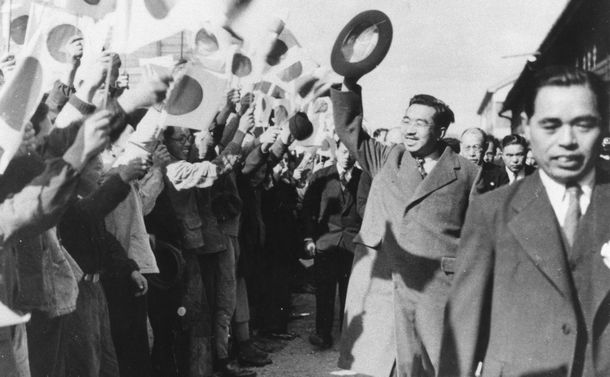 写真・図版 : 1950年、四国巡幸で歓迎する人たちに帽子を高々と振って応える昭和天皇=1950年3月20日、愛媛県松山市 
