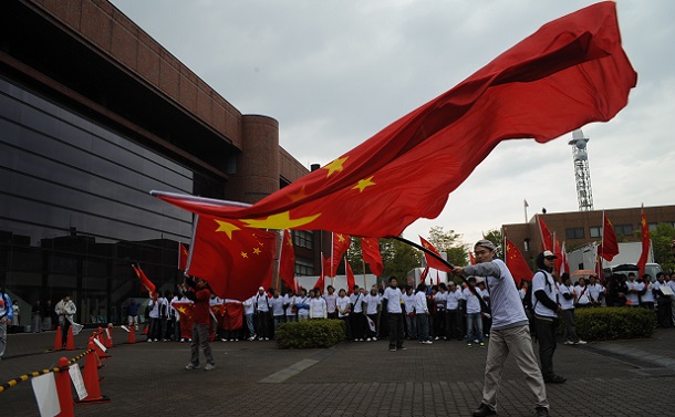 2008年の北京大会の開幕前に長野市内で行われた北京五輪の聖火リレーの会場で国旗を振る中国人留学生たち