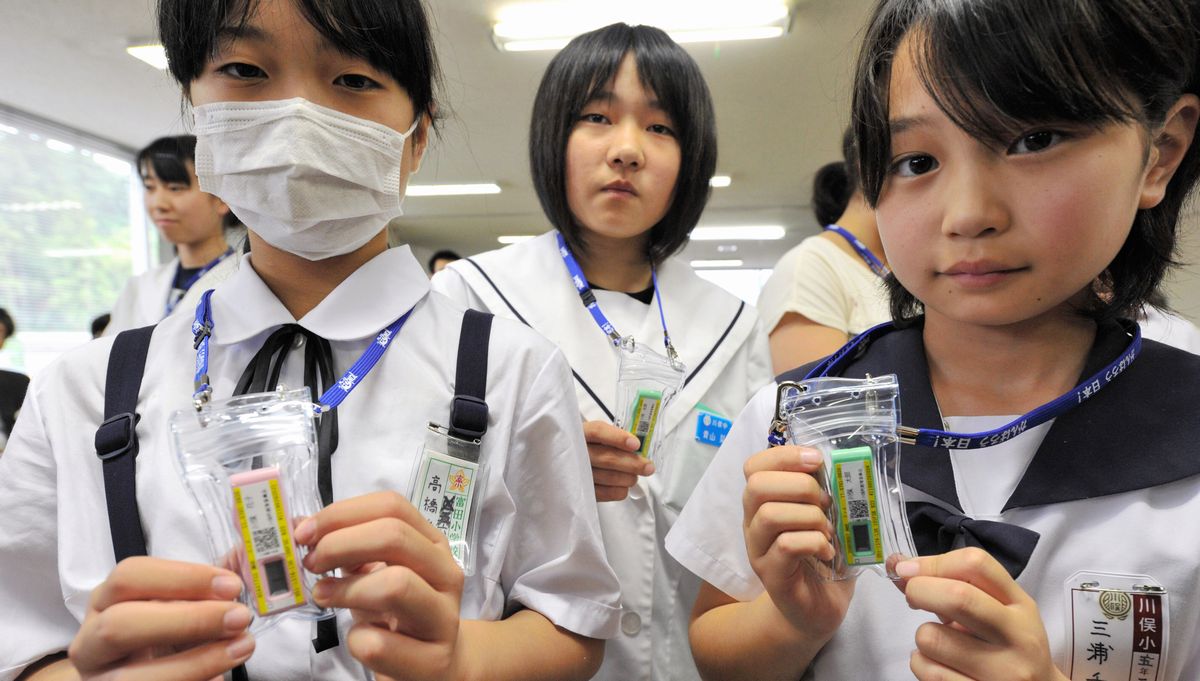 写真・図版 : 配布された線量計を手にする児童ら＝2011年6月21日、福島県川俣町