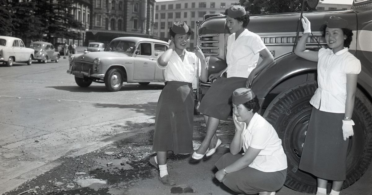 写真・図版 : 東京駅前で談笑する観光バスのガイドたち ＝1956年6月8日、東京駅前 
