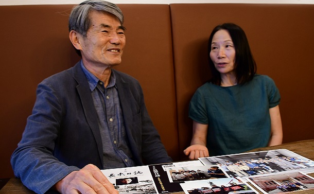 再審無罪が決定した際の写真の前で語りあう李哲さん(左)と妻の閔香淑さん=2021年6月10日、大阪市天王寺区
