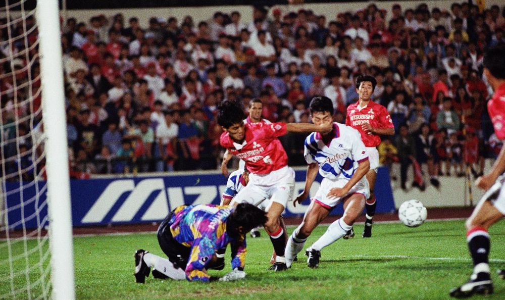 写真・図版 : 鹿島はJリーグ発足後最初のステージを制した。1993年7月7日、浦和を2-0で下し前期優勝を果たした。写真はサントスのヘディングシュートをGKがはじいたこぼれ球をシュートして2点目を決める黒崎（右）＝浦和市の駒場競技場