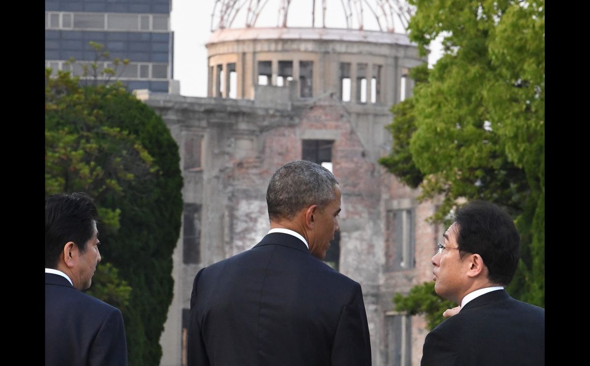 写真・図版 : 主要国の首脳として初めて広島を訪問したオバマ米大統領に、平和記念公園で説明する岸田文雄外相（当時）。左は安倍晋三首相。奥は原爆ドーム＝2016年5月27日