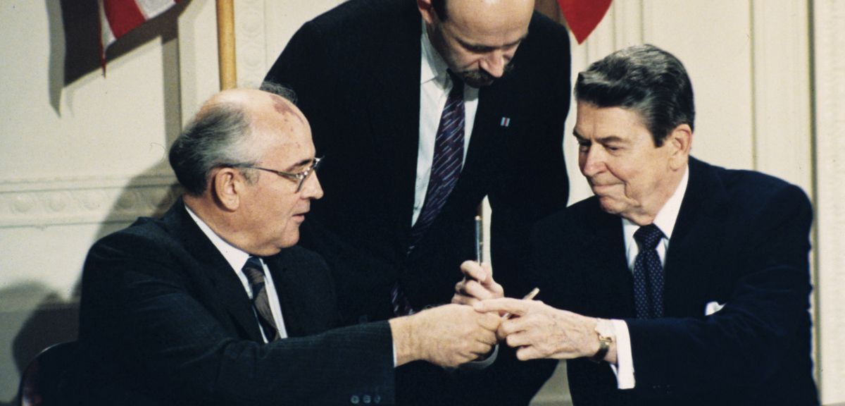 写真・図版 : 中距離核戦力（INF）全廃条約の調印式で、ペンを交換するレーガン米大統領（右）とゴルバチョフ・ソ連共産党書記長＝1987年12月8日、ワシントン
