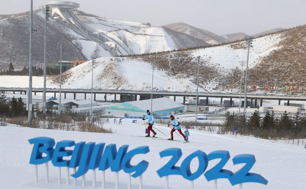 写真・図版 : 北京五輪のコースの感触を練習で確かめる日本人選手ら。奥に国家スキージャンプセンターが見える＝2022年1月31日、国家クロスカントリーセンター