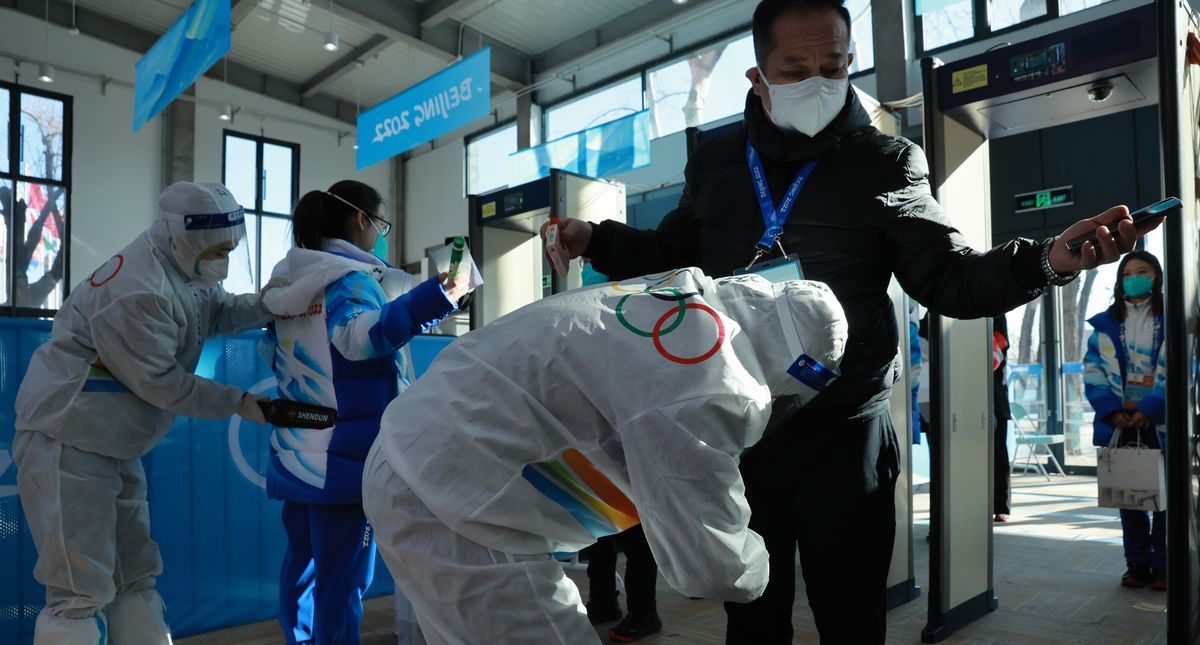 写真・図版 : オープンした北京五輪選手村に入る際の、防護服姿のスタッフによるボディーチェック＝2022年1月27日