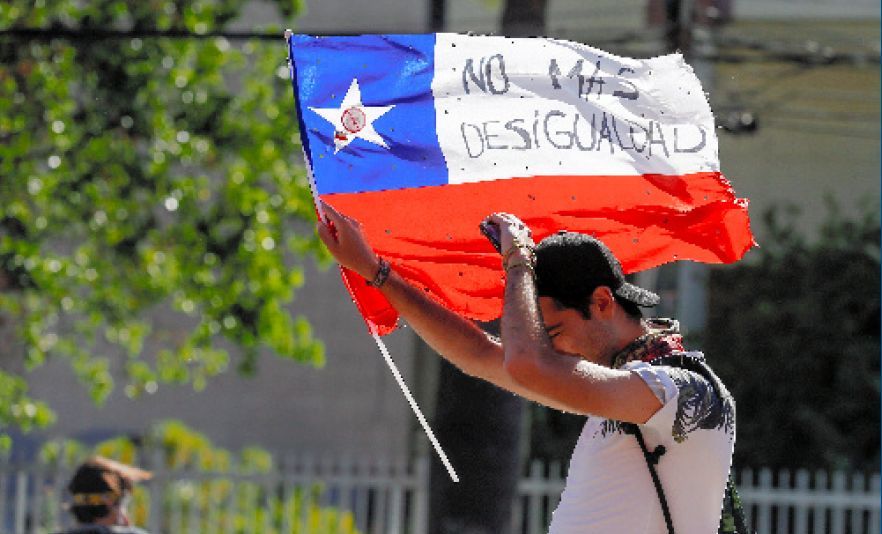 写真・図版 : 「格差はもういらない」と書かれたチリ国旗を掲げる抗議デモの参加者＝2019年11月26日