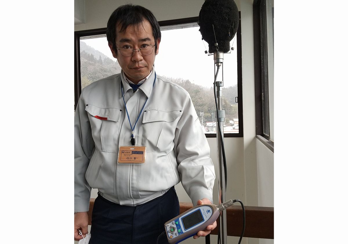 写真・図版 : 騒音測定器を操作する浜田市職員の白川敬さん。米軍機にすばやく対応する＝2021年2月、同市旭支所、筆者撮影