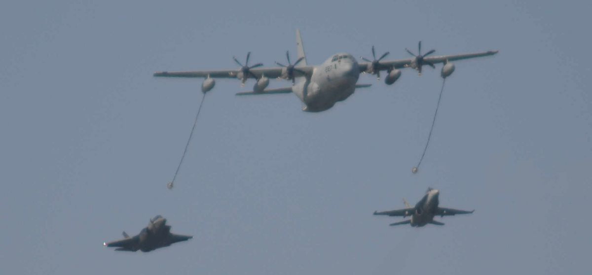 写真・図版 : 米海兵隊岩国基地のフレンドシップデーでデモ飛行する空中給油機KC130（上）と戦闘攻撃機FA18（右）。この7カ月後、両機種の同型機が空中給油訓練中に接触・墜落した。左はステルス戦闘機F35B＝2018年5月4日