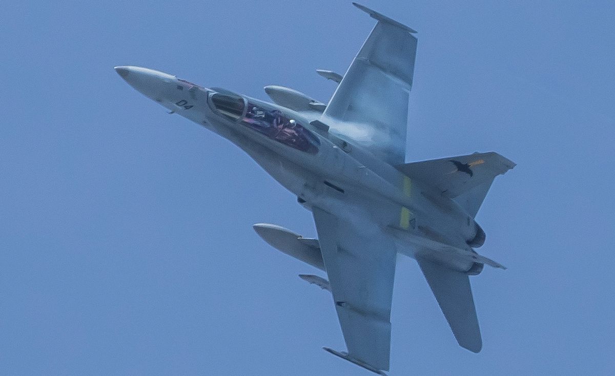 写真・図版 : 広島県北広島町の上空に飛来し、機体を傾ける米軍の戦闘攻撃機FA18。尾翼には岩国基地所属を示すコウモリのマーク＝2017年12月15日、髙木茂さん撮影