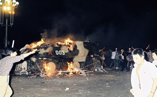 写真・図版 : 天安門事件。火焔瓶が命中し炎上する戒厳部隊の装甲車＝1989年6月4日、中国・北京の天安門前 
