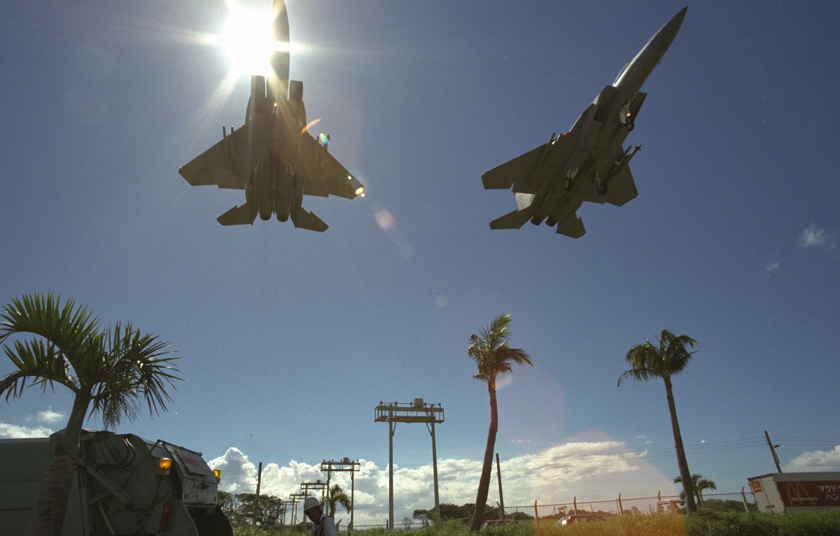 写真・図版 : 国道58号を横切り米空軍嘉手納基地に向かうF15戦闘機