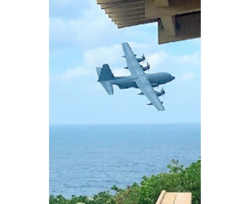 写真・図版 : 国立公園の沖縄県・慶良間諸島の座間味島で、展望台の軒先をかすめるように低空飛行する米軍機。付近には集落やキャンプ場がある＝2020年12月28日、宮平譲治さん提供