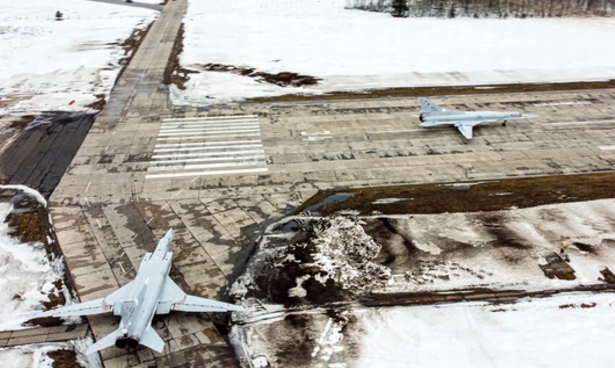 写真・図版 : 2月4日、ロシアの空軍基地で離陸のため滑走路に向かう2機の爆撃機。ロシア国防省が公表した
