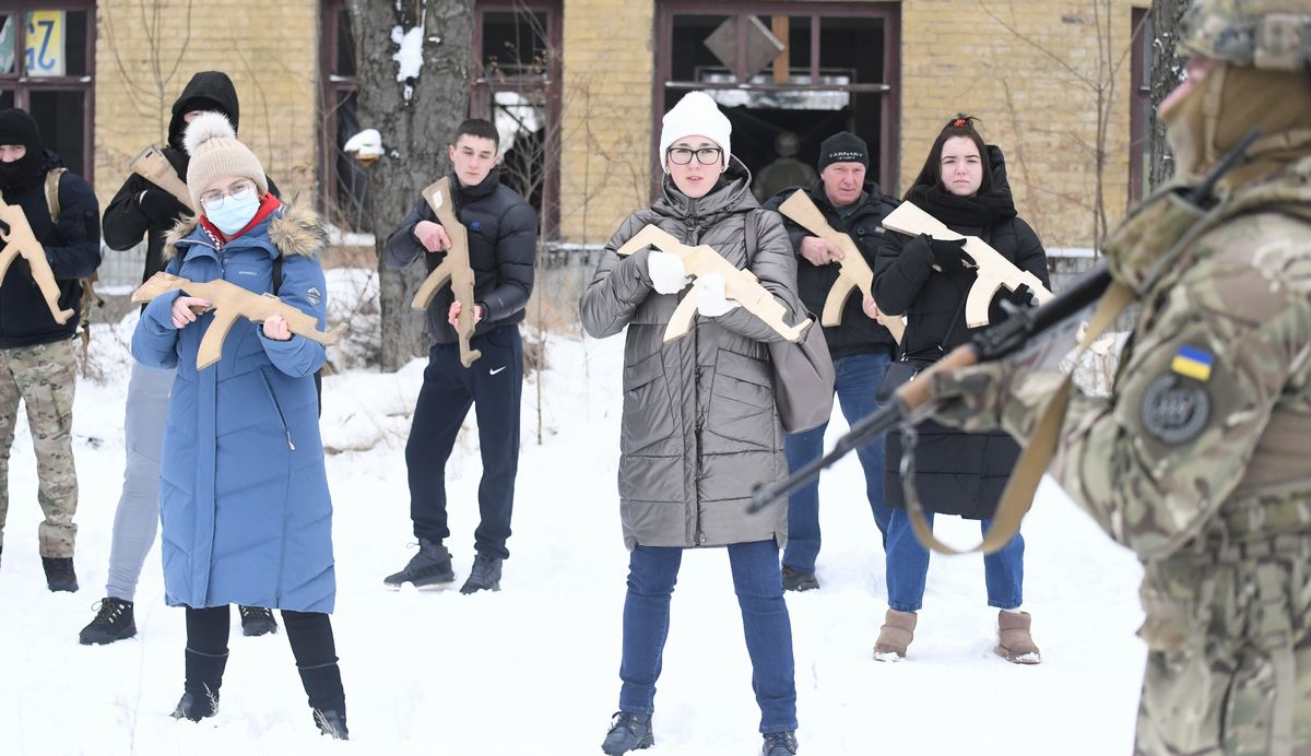 写真・図版 : ウクライナのキエフで木造模型を手に市民対象の軍事訓練に参加した大学生のアナさん（前列中央）とマリアさん（前列左）。国境周辺にロシア軍が10万人規模で展開し緊張が高まっている＝2022年1月30日