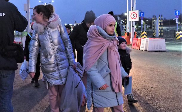 写真・図版 : 戦禍のウクライナから逃れ、ポーランドとの国境を歩いて渡ってきた人たち＝2022年2月27日、ポーランド南東部メディカ