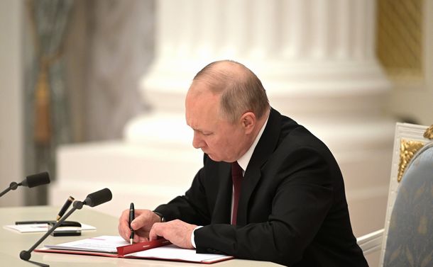 写真・図版 : モスクワで２月21日、「ドネツク人民共和国」と「ルガンスク人民共和国」の独立を承認する大統領令に署名するプーチン大統領。ロシア大統領府が写真を公表した 